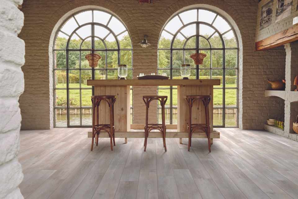 wood look luxury vinyl in kitchen with open arch windows and natural wood, exposed brick and beams